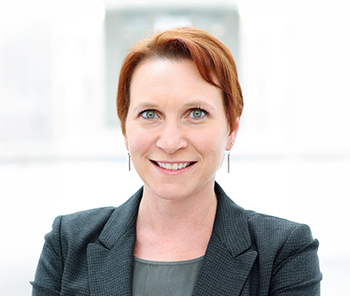 female individual with red hair wearing blazer